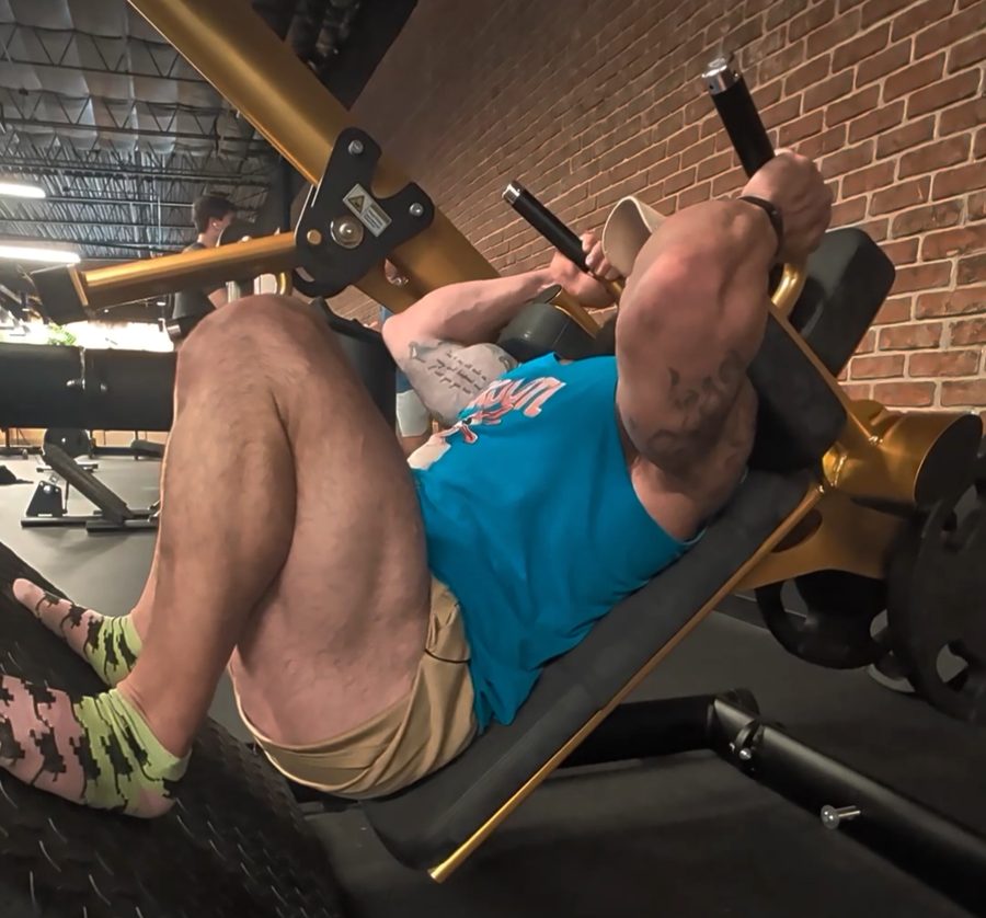 Coach Joe training on a hack squat machine